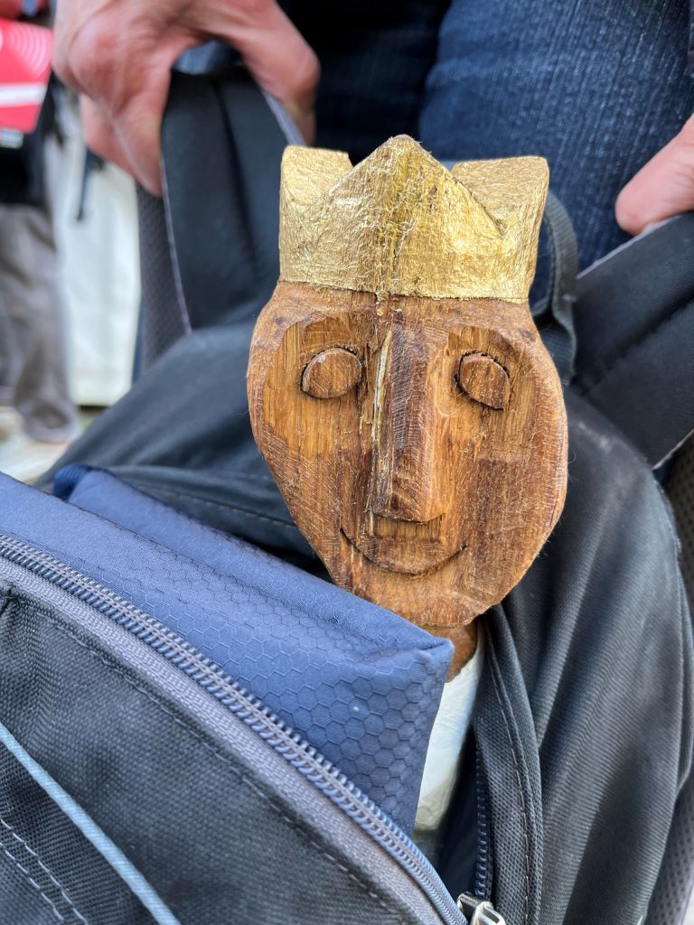 Ein in Holz geschnitzter Kopf mit einer Krone.